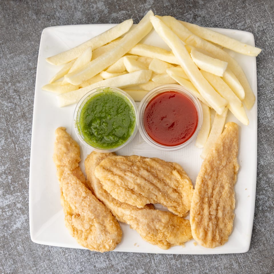A white plate holds crispy chicken tenders, golden french fries, green chutney, and red ketchup.